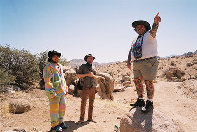 a man standing on a rock with a man pointing at something