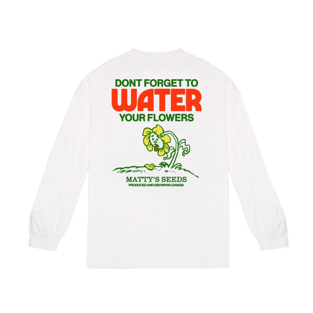 The white cotton long-sleeve shirt from Matty Matheson showcases a vibrant back graphic, featuring a cartoon flower with bold red and green text: DONT FORGET TO WATER YOUR FLOWERS, above MATTYS SEEDS.